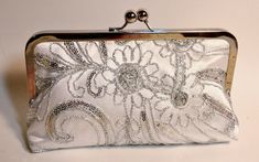 "Absolutely stunningly beautiful silver embroidered lace clutch in a daisy pattern. It is embellished with silver sequins, beads and silver thread. This is a couture fabric for the very discriminating bride! It comes with silver satin lining and silver/nickel frame. Lining can be changed to your custom color. Fabric: Beaded Lace Lining: satin Two layers of interlining and batting Silver/nickel kisslock frame Top Width 8\" Bottom Width 9\" Height 5 1/2\" Reinforced stitching for durability *Note: Old Wedding Dresses, Personalized Purse, Silk Clutch, Bridesmaid Clutches, Bridal Purse, Wedding Bags, Lace Bride, Custom Bouquet, Bridal Bag