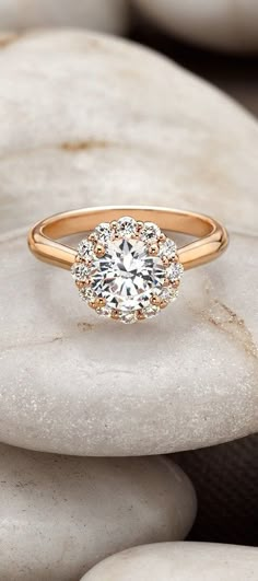 a gold engagement ring with a diamond center surrounded by rocks