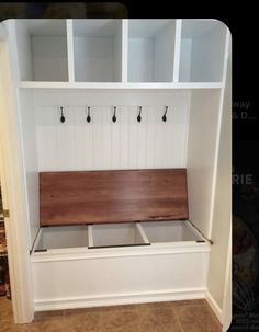 a white bench with wooden seat and coat rack