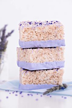 three pieces of cake sitting next to each other on a blue plate with lavender sprinkles