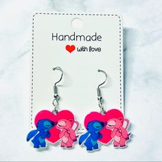 pink and blue heart shaped earrings with two little ponies hanging from it's ear hooks