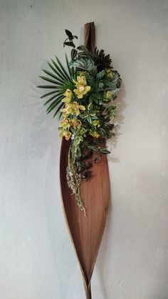 a wooden spoon with flowers on it hanging from the wall next to a white wall