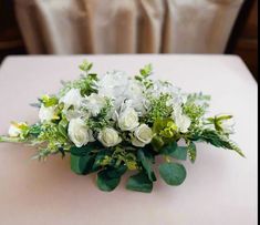 a bouquet of white flowers sitting on top of a table