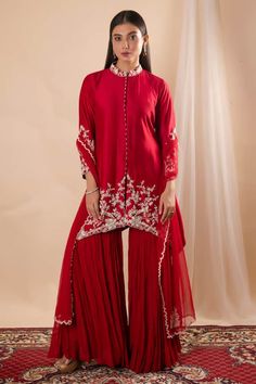 Red asymmetric straight kurta featuring floral and bead pattern bead hand embroidery on the hem and collar. Paired with a solid sharara and an embroidered hem dupatta. - Aza Fashions Fitted Red Sharara For Transitional Season, Red Fitted Sharara For Transitional Seasons, Red Designer Wear Sharara With Straight Kurta, Red Sharara With Traditional Drape, Red Sharara With Resham Embroidery, Red Sharara With Straight Kurta For Wedding, Designer Red Sharara With Sheer Dupatta, Elegant Red Sharara For Transitional Season, Red Sharara For Reception