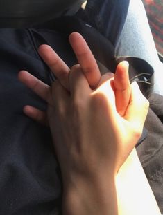 a person holding their hand up to the camera with both hands on top of each other