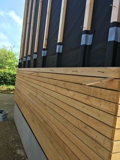 the side of a wooden building with black and white stripes on it's sides