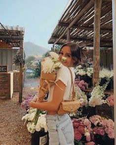 a woman is holding flowers in her hands