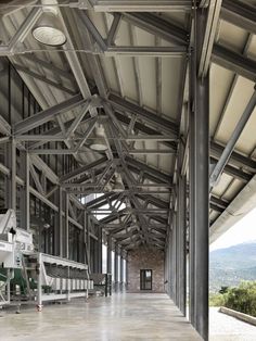 the inside of an industrial building with large windows and metal beams on both sides of it