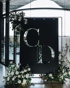 the letters b are surrounded by flowers and greenery in front of a black backdrop