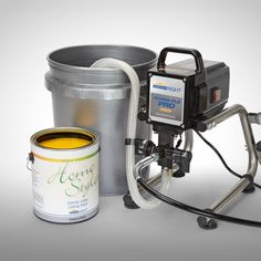 a paint bucket, can and sprayer sitting next to each other