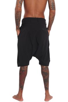 Breathable, super lightweight, water resistant active fabric meets tailored structure in these black techwear shorts. The Dublin Mens Drop Crotch Shorts have a streetwear aesthetic but function as a multi purpose garment. Comfortable enough to lounge in and suitable to swim in; the perfect shorts for travelers and spontaneous souls. FEATURES: Harem style: low dropped crotch Long length, hits just below the knee Four pockets, two with zippers, one of which is hidden Belt loops Diagonal zip fly Ma Summer Techwear Cargo Shorts, Summer Techwear Shorts, Streetwear Techwear Shorts, Techwear Shorts For Summer, Summer Techwear Short Pants, Functional Baggy Black Bottoms, Functional Black Baggy Bottoms, Techwear Style Shorts For Streetwear, Black Techwear Shorts For Streetwear