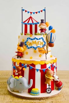 a three tiered circus themed cake on a table