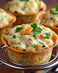 small quiche cups with carrots, peas and parsley in them on a wire rack