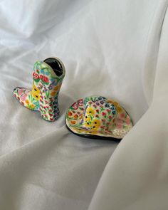 two ceramic shoes are sitting on a white sheet