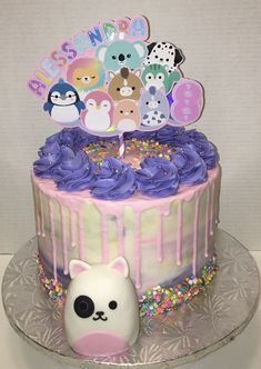 a birthday cake with purple frosting and decorations on the top is decorated with animals