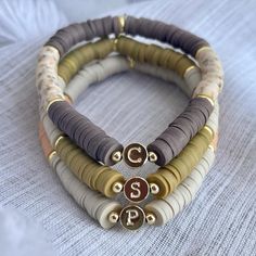 Includes ONE stretchy heishi bead bracelet with a hand stamped 14k gold plated letter bead.  *must choose all lower case or all upper case* You can choose two different heishi color beads or select the same color for both dropdowns to make the bracelet all one color. Click the link below to add on a stamped coin charm! https://www.etsy.com/listing/1380899207/add-on-stamped-14k-gold-plated-coin?click_key=650f4dd3185cd97e3057951ca8aed30e0eb7c574%3A1380899207&click_sum=db389c18&ref=shop_home_feat_4 Heishi Jewelry, Heishi Bead Bracelet, Clay Bracelets, Matching Couple Bracelets, Mama Bracelet, Bracelets Handmade Diy, Black Beaded Bracelets, Clay Bracelet, Beads Bracelet Design