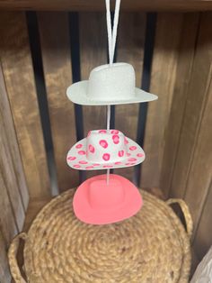 three hats are hanging from the top of a basket