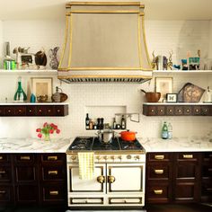 a stove top oven sitting inside of a kitchen next to wooden cabinets and counter tops