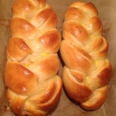 two braided breads sitting on top of a piece of wax paper next to each other