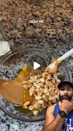 a man standing in front of a glass bowl filled with nuts