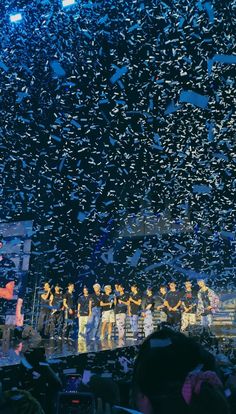 a group of people standing on top of a stage surrounded by confetti