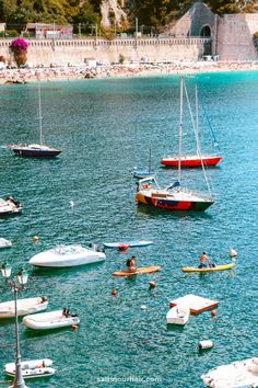 several small boats floating on top of a body of water