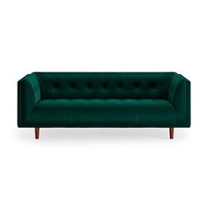 a green velvet couch with wooden legs and buttons on the back, sitting against a white background