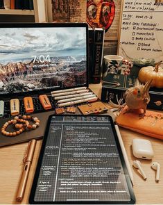 a laptop computer sitting on top of a wooden desk next to other electronics and accessories