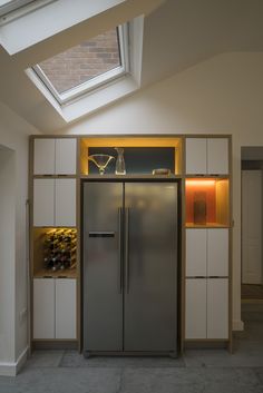 a metallic refrigerator freezer sitting inside of a kitchen next to a skylight above it