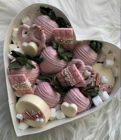 a heart shaped box filled with pink and white chocolate covered in marshmallows