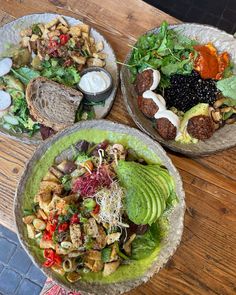 two bowls filled with different types of food on top of a wooden table next to each other