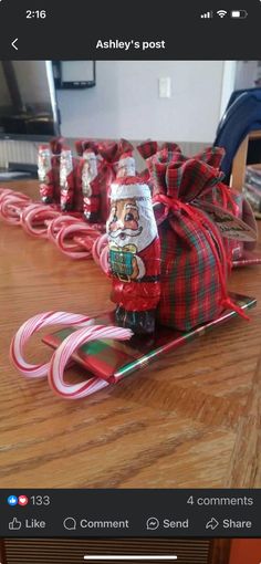 a wooden table topped with candy canes and santa clause figure on top of it