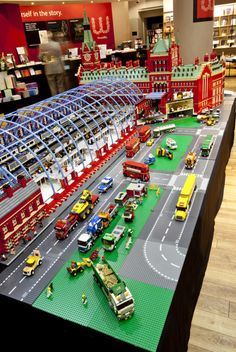 a table that has some cars and trucks on it in front of a store display