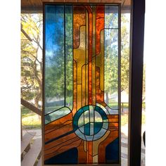 a stained glass window with an abstract design on the front and side panels in different colors