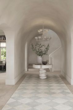 a white room with a checkered floor and chandelier