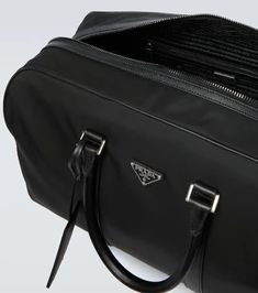 A spacious and versatile style with contemporary flair, this Prada duffel bag is crafted from sustainable Re-Nylon in black, features iconic Saffiano leather trims for an elegant touch, and comes with a removable shoulder strap..Trim: calf leather.Material: fabric.Comes with dust bag.Designer color name: Nero.Internal details: internal zipped pockets, fabric lining.Made in Italy.Color of fastening: silver.Closure: zipped top.Detachable, adjustable shoulder strap, Top handles.Height 30cm-12'.Widt Leather Duffel Bag, Leather Duffel, Travel Collection, Duffel Bag, Color Names, Prada Bag, Travel Luggage, Luggage Bags, Leather Trims