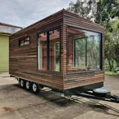 a tiny house on wheels parked in a lot