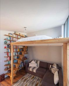 a living room with a couch under a book shelf