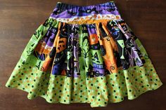 a colorful skirt is hanging on a wooden floor with polka dots and monsters all over it