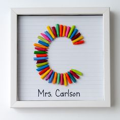 a white frame with colorful crayons in the shape of a letter c on it