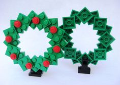 two legos made to look like christmas wreaths with red and green decorations on them