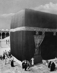 an old photo of people standing in front of a large building