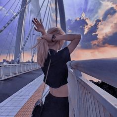 a woman standing on top of a bridge