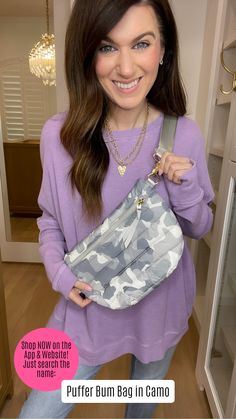 a woman holding a camo purse in her hands