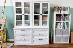 a white bookcase with glass doors and drawers