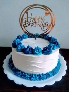 a white cake with blue ruffles and a happy birthday sign