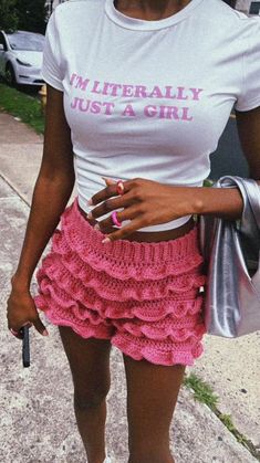 a woman wearing a white t - shirt and pink ruffle skirt