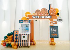 an orange and white welcome sign next to a vending machine with basketballs on it