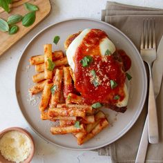 a white plate topped with french fries covered in sauce