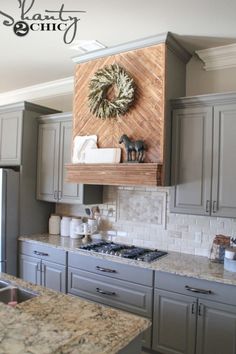 a kitchen with granite counter tops and stainless steel appliances in front of a wreath hanging on the wall